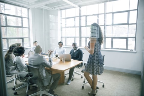 Businesswoman talking behind window in meeting