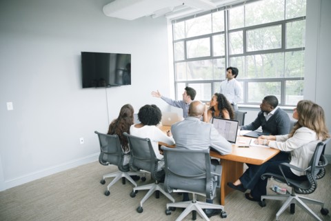 Businessman talking near visual screen in meeting