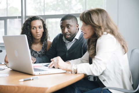 Business people using laptop in meeting