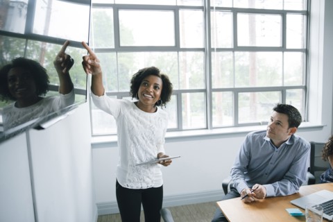 Businesswoman talking near visual screen in meeting