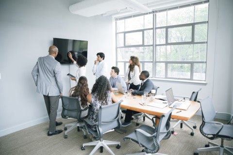 Businesswoman talking near visual screen in meeting