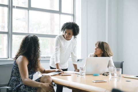 Businesswomen using laptop in meeting