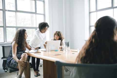 Businesswomen using laptop in meeting