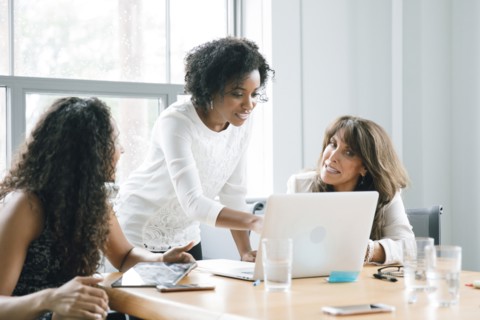 Businesswomen using laptop in meeting