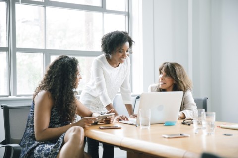 Businesswomen using laptop in meeting