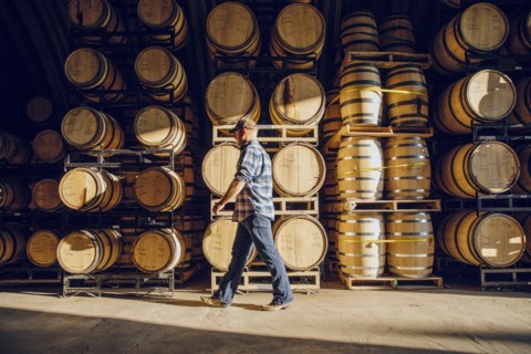 Caucasian man walking near barrels in distillery