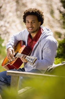 African American man playing acoustic guitar