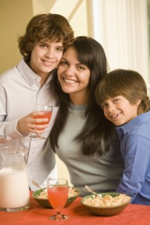 Hispanic mother and sons eating breakfast