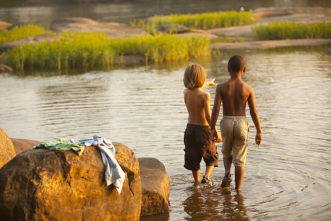 Boys wading in lake together