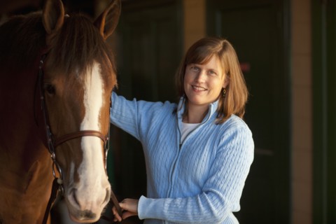 Caucasian woman standing with horse