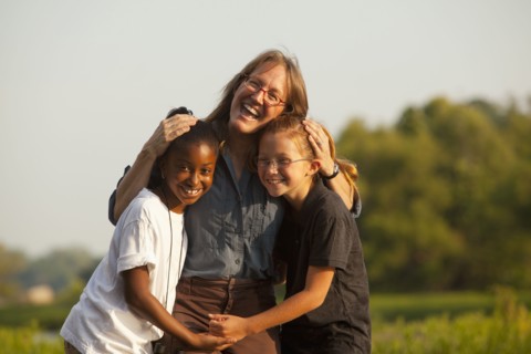 Teacher hugging students outdoors