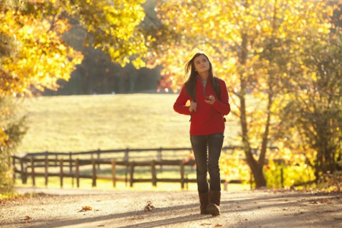Caucasian girl walking on road in countryside