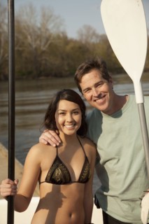 Smiling couple holding oars
