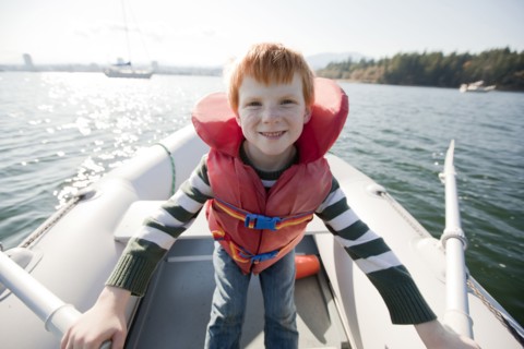 Caucasian boy rowing on boat