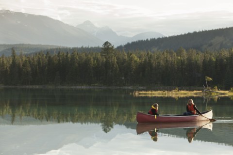 Caucasian mother and daughter canoeing on Lake Edith