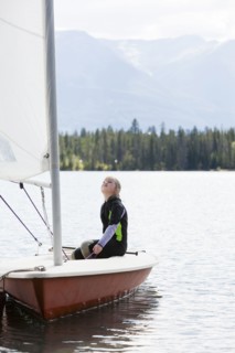 Girl sitting in sailboat looking up