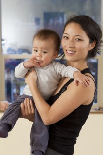 Smiling Korean mother holding baby