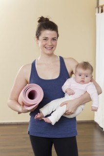 Caucasian mother holding baby in yoga studio
