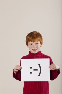 Caucasian boy holding card with smiley face