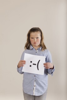 Caucasian boy holding card with sad face