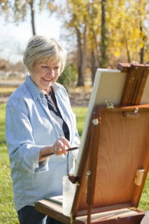 Senior woman painting outdoors