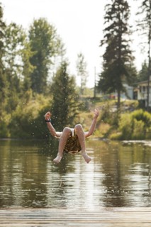 Caucasian boy jumping into lake
