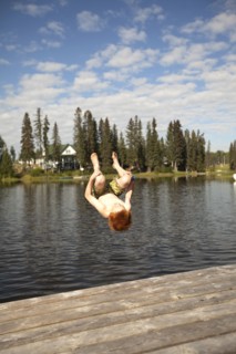 Caucasian boy jumping into lake