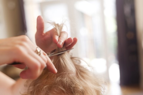 Caucasian mother cutting hair of son