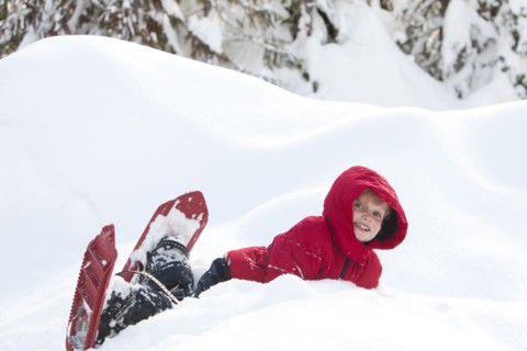 Caucasian boy snowshoeing on hillside