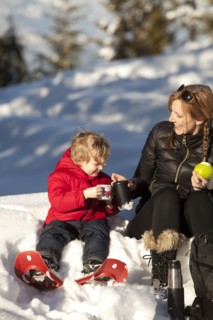 Caucasian mother and son drinking hot cocoa in snow
