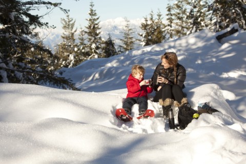 Caucasian mother and son drinking hot cocoa in snow