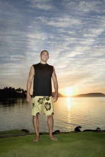 Asian man next to water at sunset