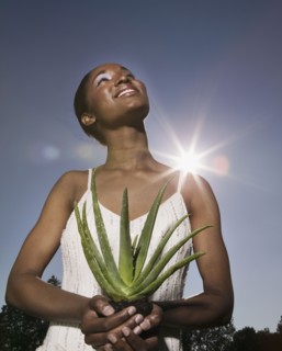 African woman holding aloe plant
