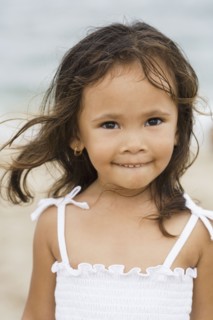 Mixed race girl smiling on beach
