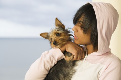 Hispanic teenage girl holding dog