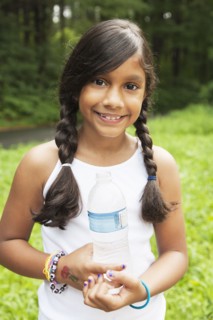 Smiling Hispanic girl holding bottled water