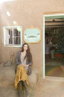 Hispanic teenage girl sitting near doorway to shop