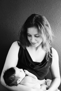 Mother holding baby son near wall