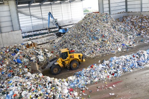 Bulldozer pushing pile of trash
