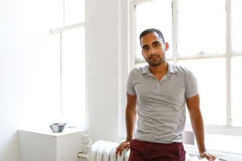 Mixed race man leaning on radiator