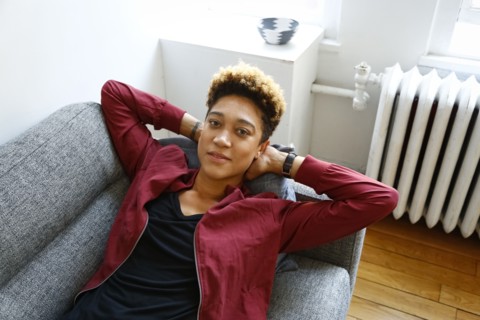 Portrait of smiling mixed race woman relaxing on sofa