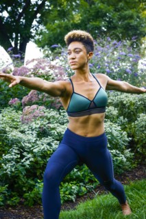 Mixed race woman performing yoga in park