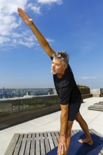 Caucasian man performing yoga on urban rooftop