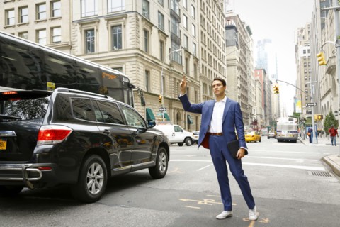 Caucasian businessman standing in street hailing taxi