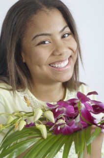 Teenage girl holding a bunch of purple flowers