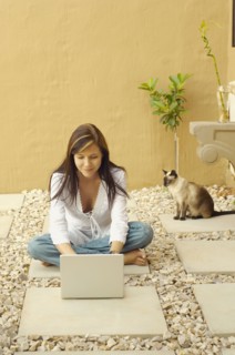 Woman with laptop and cat outdoors