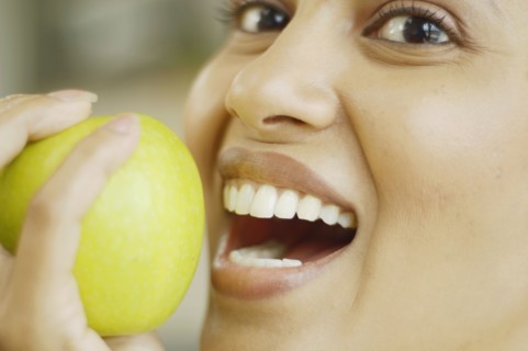 Close up of woman about to bite into an apple