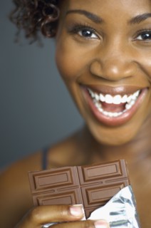 African woman eating chocolate bar