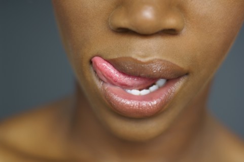 Close up of African woman licking lips