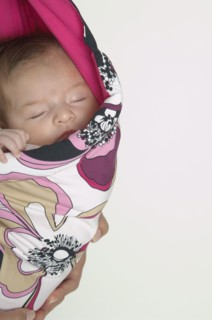 Hispanic baby sleeping in wrap